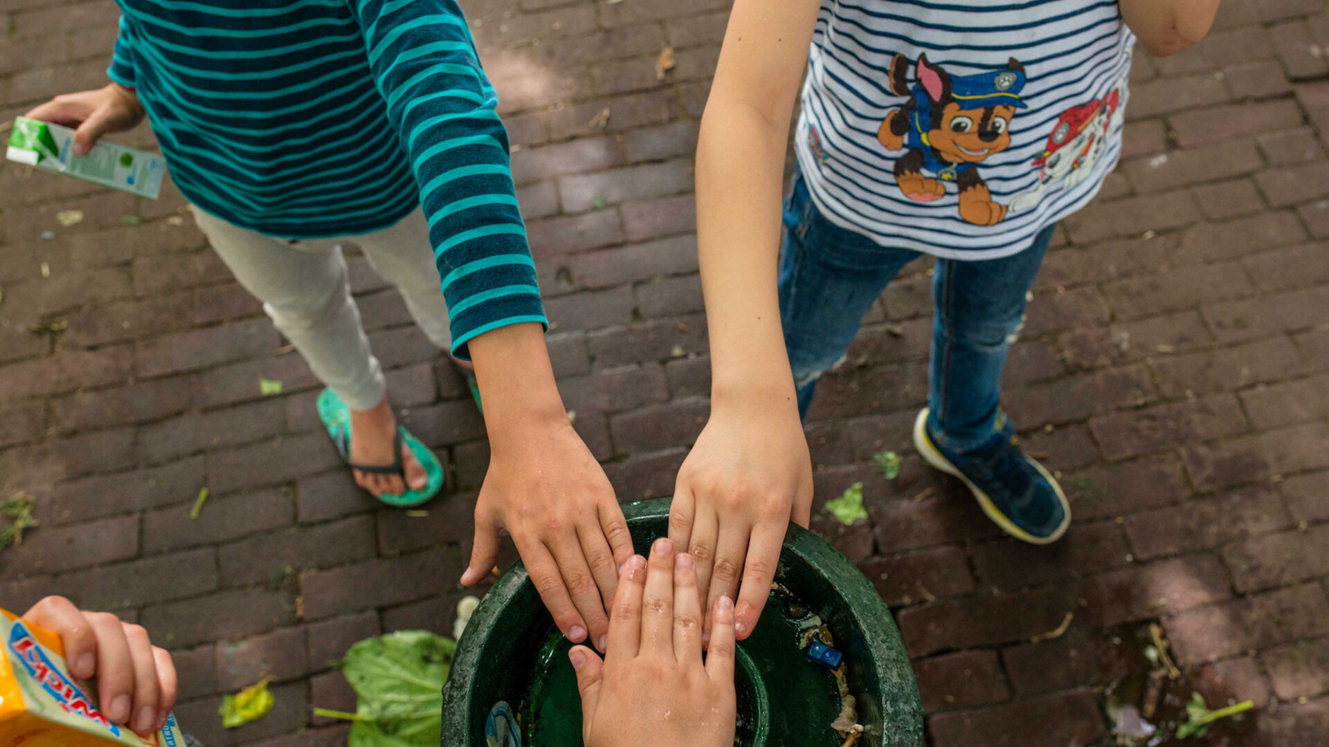 Drie kinderen slaan de handen in elkaar